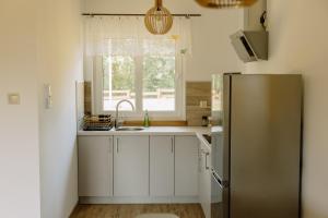a kitchen with a stainless steel refrigerator and a window at Ostoja nad Gilem in Ostrów Wielki