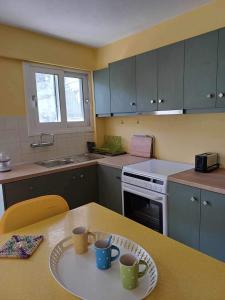 a kitchen with a table with two mugs on it at Kefalonia Alexis house in Pilaroú +37 photos