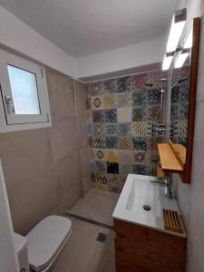 a bathroom with a toilet and a sink at Kefalonia Alexis house in Pilaroú