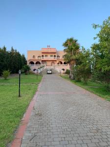 un camino de ladrillo frente a un gran edificio en Villa Cabonegro UNIQUEMENT POUR FAMILLES, en Cabo Negro