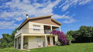 ein Haus mit einem Balkon und lila Blumen in der Unterkunft Vivienda Vacacional El Cuetu del Sella in Llames de Pría