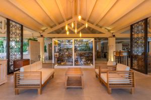 a lobby with couches and chairs and a table at Hotel Costa dei Fiori in Santa Margherita di Pula
