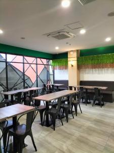 a dining room with tables and chairs and windows at Wisma Davinci PematangSiantar in Pematangsiantar