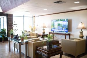 サマセットにあるQuality Inn & Conference Centerのソファと薄型テレビのあるロビー