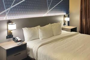 Una cama en una habitación de hotel con un teléfono. en Comfort Suites Simpsonville - Greenville, en Simpsonville