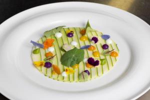 a plate with a salad on a white plate at Hotel Costa dei Fiori in Santa Margherita di Pula