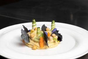 a white plate with a salad with vegetables on it at Hotel Costa dei Fiori in Santa Margherita di Pula