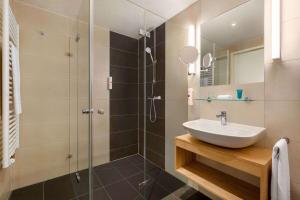 a bathroom with a sink and a shower at Wyndham Garden Munich Messe in Munich