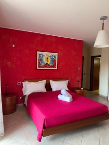 a red bedroom with a large bed with a red wall at Regina Margherita B&B in Amantea +23 photos
