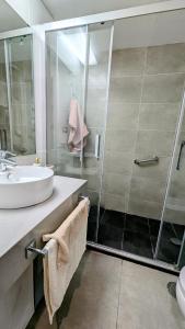 een badkamer met een glazen douche en een wastafel bij Rincón del Atlántico in Rota