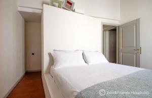 a white bed in a room with a window at Casa Alceo in Pesaro