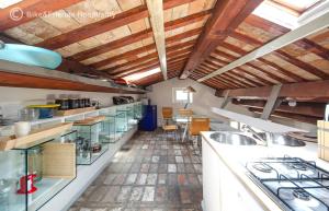 a large kitchen with wooden ceilings and wooden counters at Casa Alceo in Pesaro +8 photos