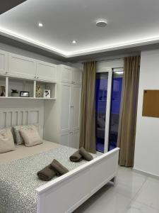 a white bedroom with a large bed and a window at Premium Studio DANAI 14 Paralia Beach in Paralia Katerinis