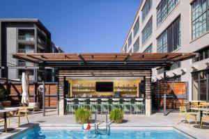 an outdoor patio with a pool and a building at Fordson Hotel, in the Unbound Collection by Hyatt in Oklahoma City