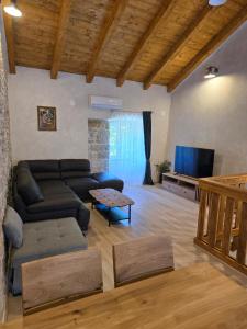 a living room with a couch and a tv at Apartments Rose 5 in Cres