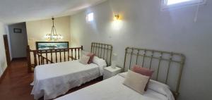 ein Schlafzimmer mit zwei Betten und einem Kronleuchter in der Unterkunft Vivienda Vacacional El Cuetu del Sella in Llames de Pría