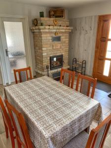 a dining room with a table and a fireplace at Boróka Vendégház Gerjen in Gerjen