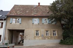 an old house with blue shuttered windows on it at Castillo 1 in Ensheim