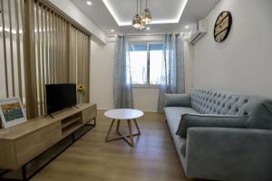 a living room with a couch and a tv at Helianthus, by Bloom Apartments in Central Tirana in Tirana