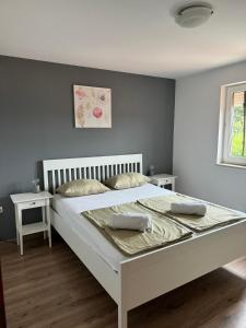 une chambre avec un grand lit blanc avec deux oreillers dans l'établissement Apartments Dumicic, à Rab