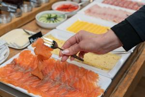 a person is cutting fish on a plate of food at Boutique hotel & brasserie de Heerlyckheid in Bredevoort