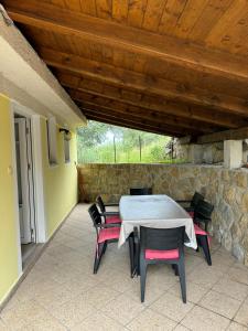 une table et des chaises sur une terrasse avec un mur en pierre dans l'établissement Apartments Dumicic, à Rab
