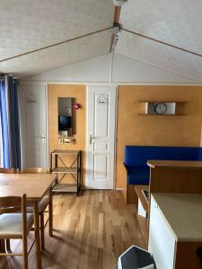 un soggiorno con tavolo e sedia blu di Jolie mobil home à louer a Thiviers