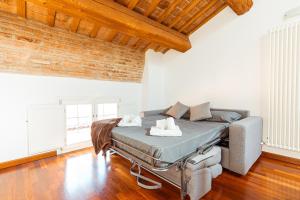 a bedroom with a bed and a couch in a room at Mansarda Colombo - Car Parking in Ferrara
