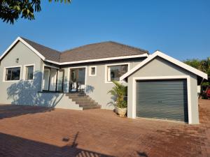 a house with a garage door on a brick driveway at Troon Harmony - Room 2 in Durban