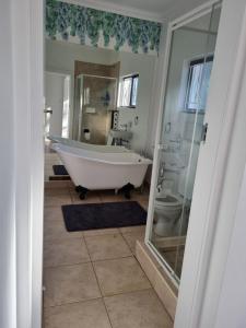 y baño con bañera y aseo. en Troon Harmony - Room 2, en Durban 15 fotos más
