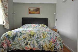 Un dormitorio con una cama con un edredón colorido. en Sennen Cove, The Hedgerows, near 14 beaches,, en Penzance