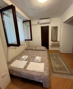 a bedroom with a bed with two towels on it at Apartman Allegre in Herceg-Novi