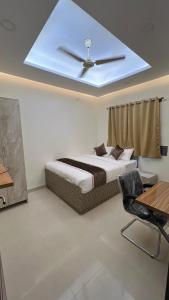 Un dormitorio con una cama con ventilador de techo. en Hotel Subha Residency Bangalore, en Bangalore