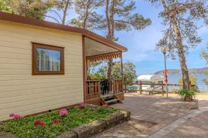a house with a gazebo next to the water at Camping Village Le Calanchiole in Capoliveri