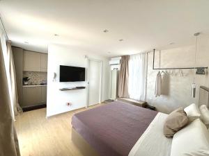 a hotel room with a bed and a flat screen tv at Lux apartments in Porto Cesareo +60 photos