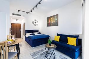 a living room with a bed and a blue couch at Apartament Hanza Tower 218 in Szczecin +14 photos