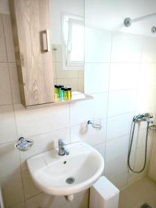 a white bathroom with a sink and a mirror at Dolphin Rooms in Antiparos +52 photos