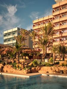 a resort with a swimming pool in front of a building at Bikini Island & Mountain Hotel Es Trenc -Adults only- in Colonia Sant Jordi