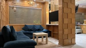 a living room with a blue couch and a table at شقق وافي حائل للشقق المخدومة إقتصادي in Hail