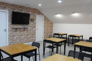 a room with tables and chairs and a tv on a brick wall at Гостевой Отель-125 in Aktau