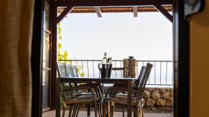 a table and chairs on a balcony with a view of the ocean at Luka private beach in Dobra Voda