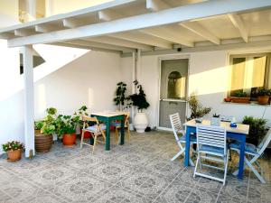an outdoor patio with tables and chairs and plants at Dolphin Rooms in Antiparos