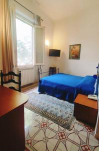 a bedroom with a blue bed and a window at Villa Al Piano in Lastra a Signa