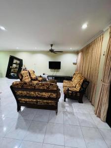 a living room with a couch and a chair at Taman Kemena Raya Bintulu Homestay in Bintulu