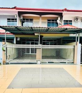 a house with a white fence in front of it at Taman Kemena Raya Bintulu Homestay in Bintulu