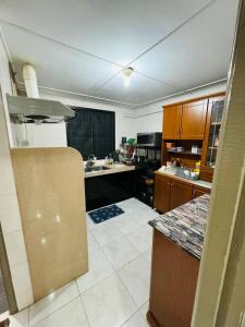 a kitchen with wooden cabinets and a counter top at Taman Kemena Raya Bintulu Homestay in Bintulu