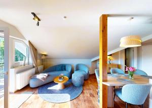 Una sala de estar con un sofá azul y una mesa. en Edelweiss Appartements 'ETTELSBERG' deluxe inkl Wellness-Spa und MeineCardPlus, en Willingen