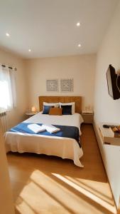 ein Schlafzimmer mit einem großen Bett mit blauer Bettwäsche in der Unterkunft Casa Da Veiga in Caminha