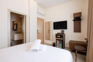 a hotel room with a white bed and a tv at Hotel El Toro Tanger in Tangier