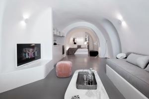 a white living room with a couch and a tv at Elegant Santorini House 3 Bedroom Villa Caldera View-Outdoor Hot Tub Oia in Thólos